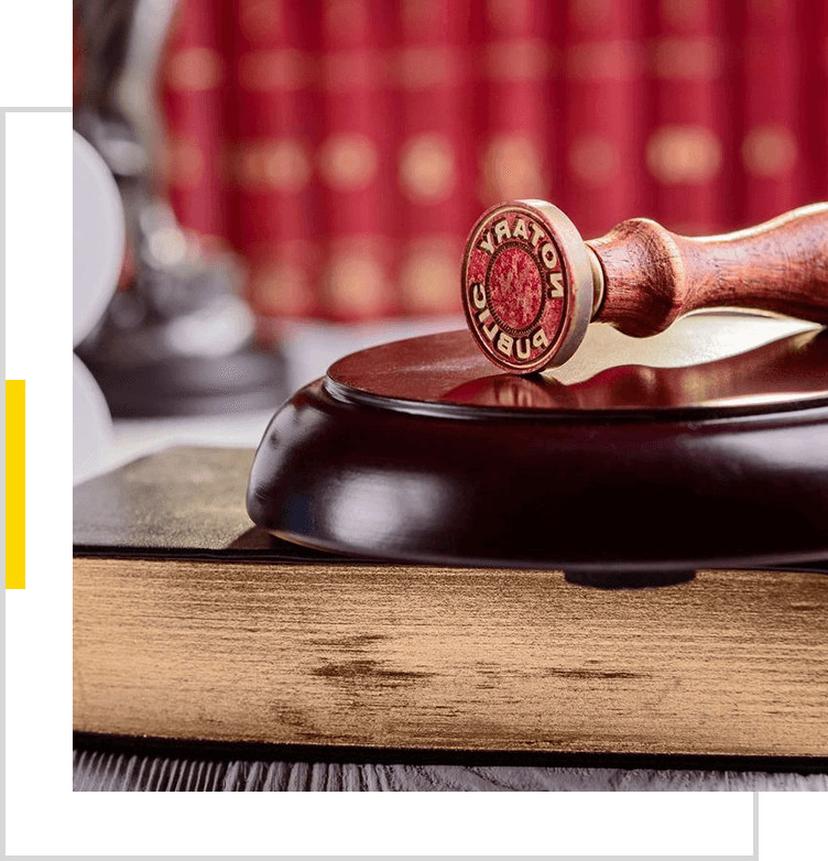 A wooden gavel sitting on top of an old book.